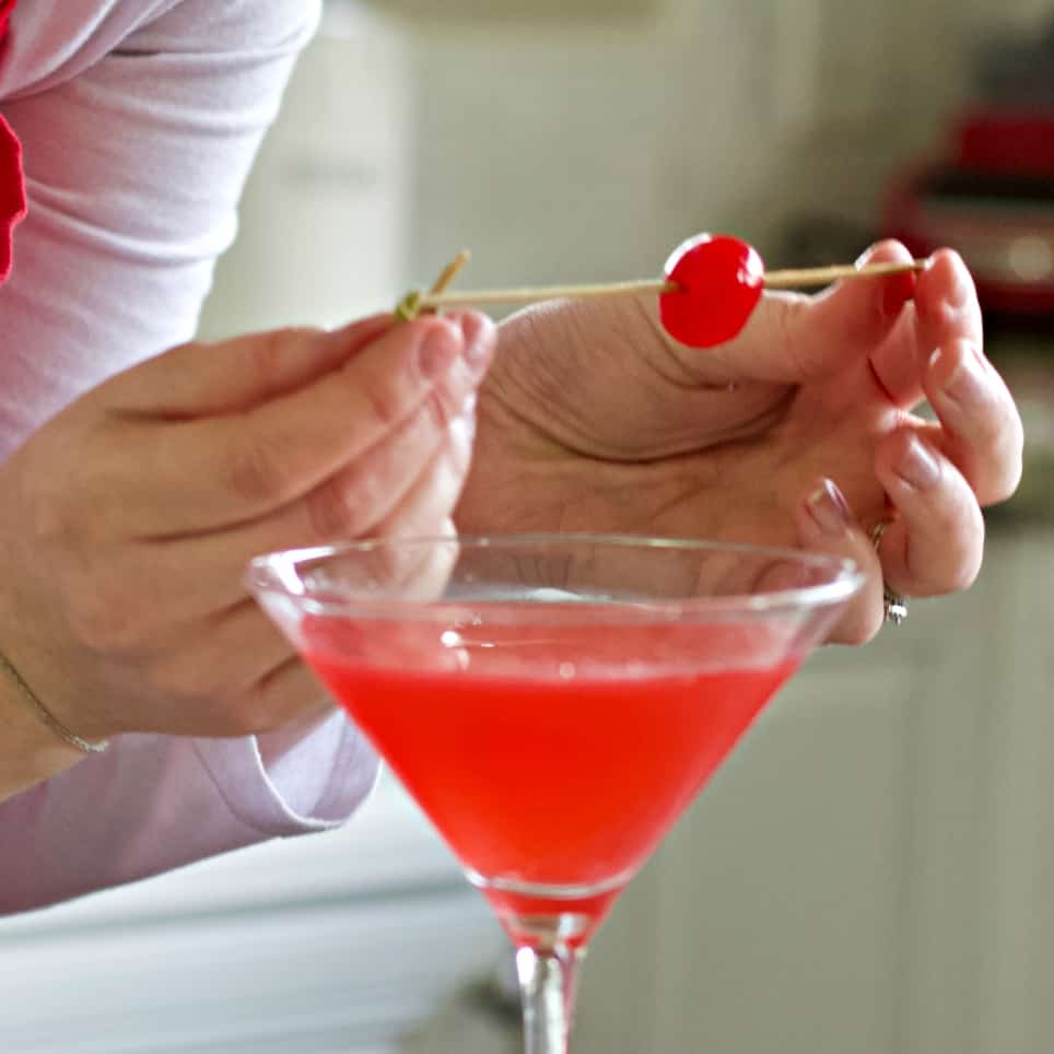 Holding a maraschino cherry on a bamboo pick