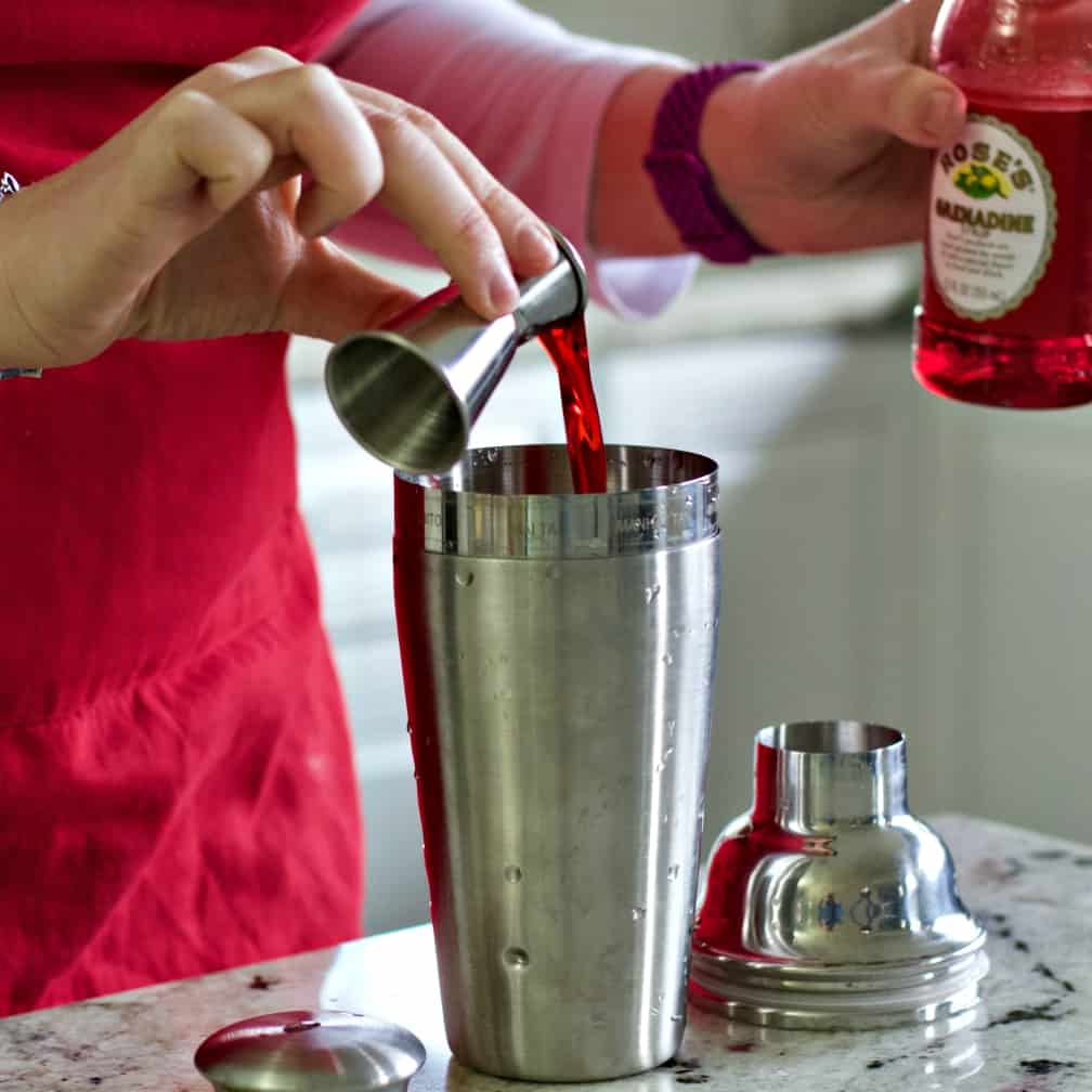 pouring grenadine into shaker.