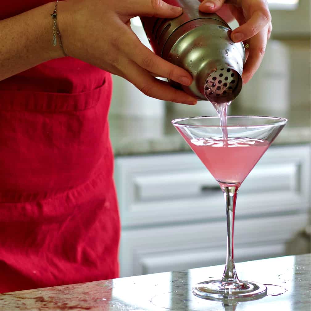 strain the cosmopolitan drink from the shaker
