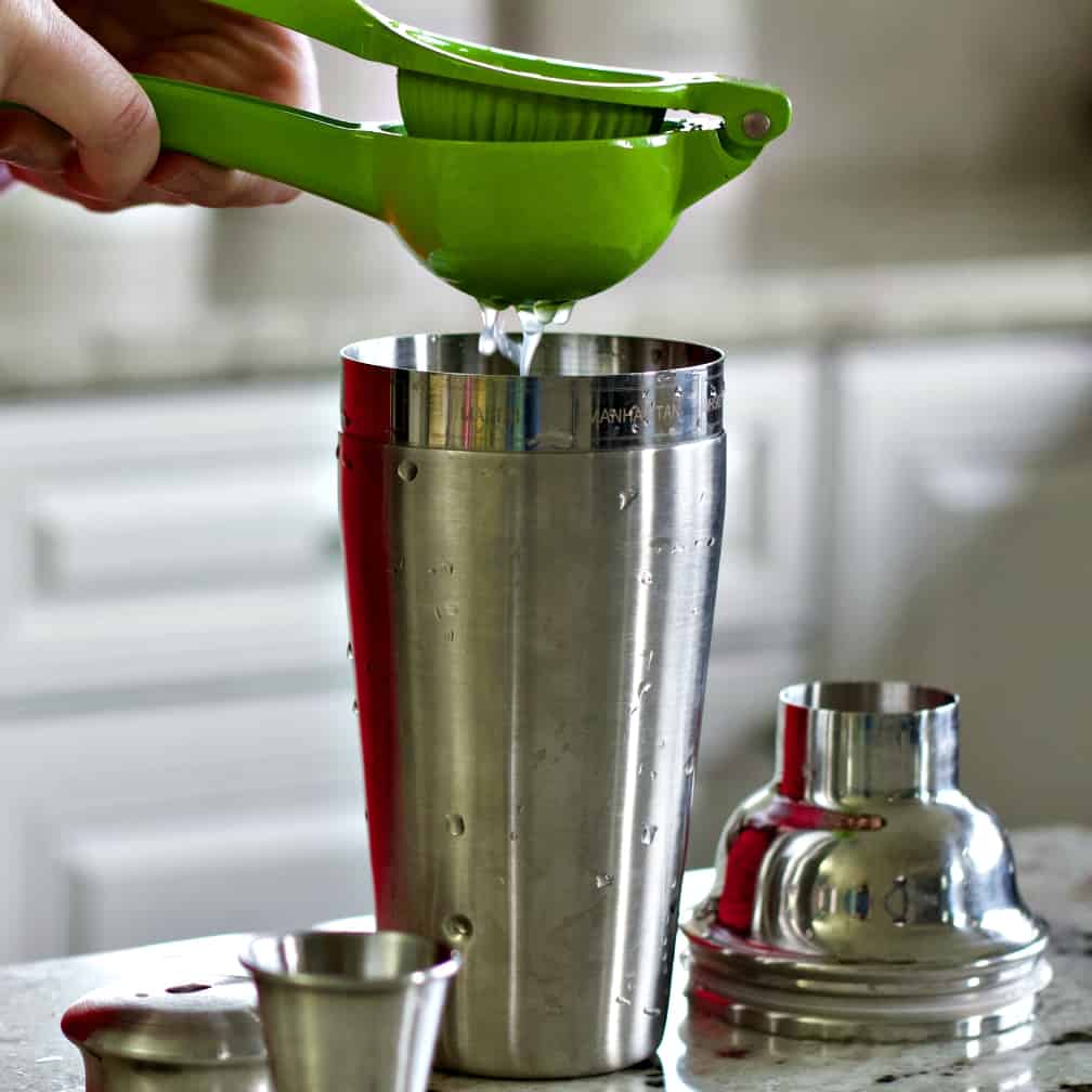 squeezing a lime into the shaker