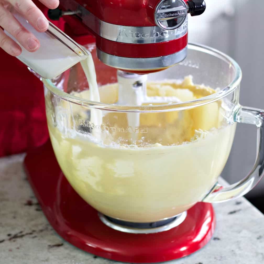 pouring milk into muffin batter.