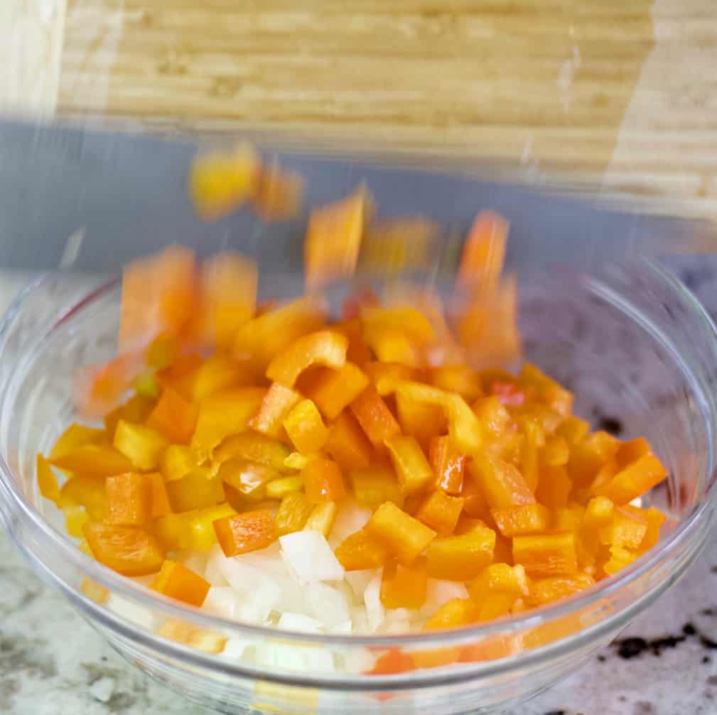 mixing peppers and onions