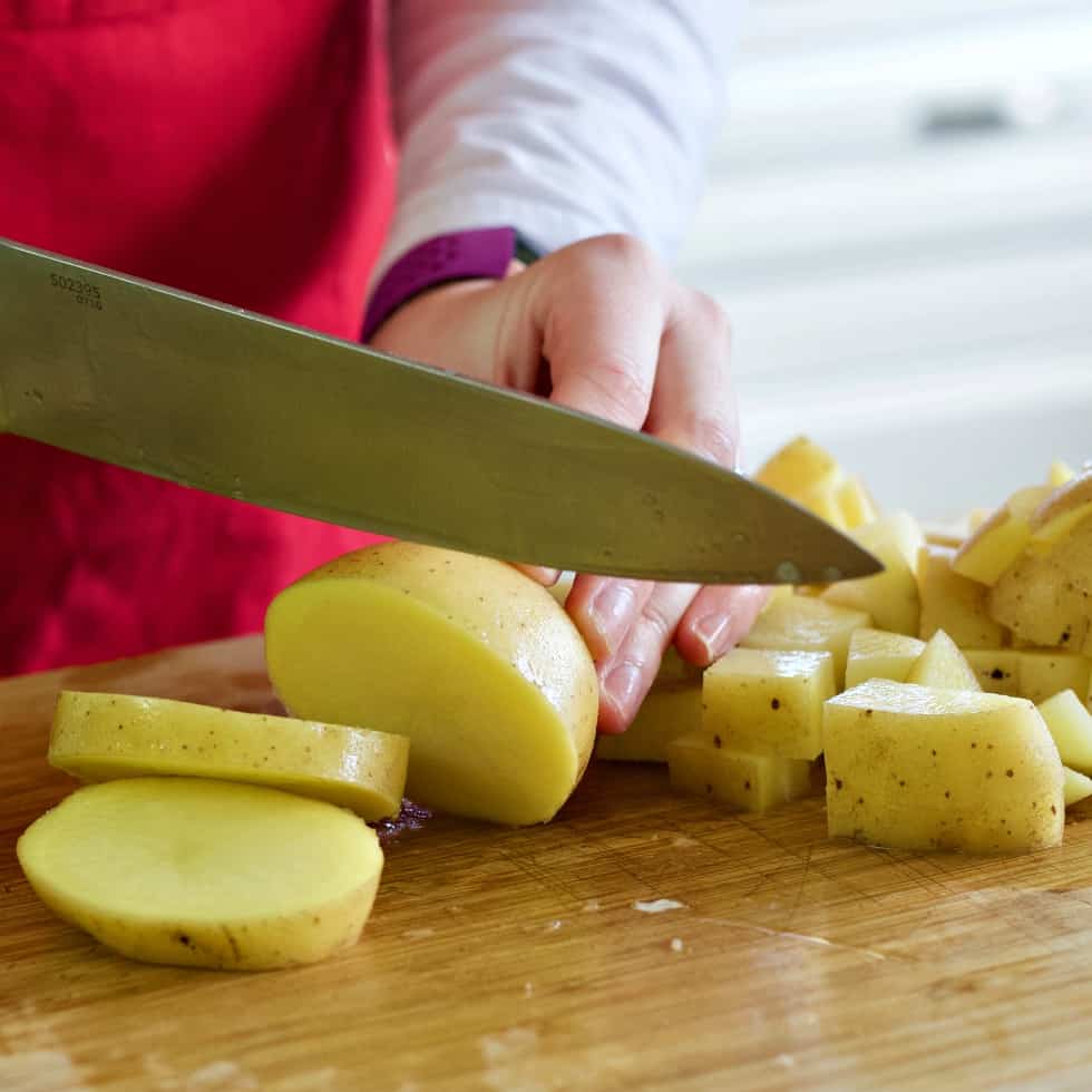 chopping yukon gold potatoes-rotisserie chicken soup