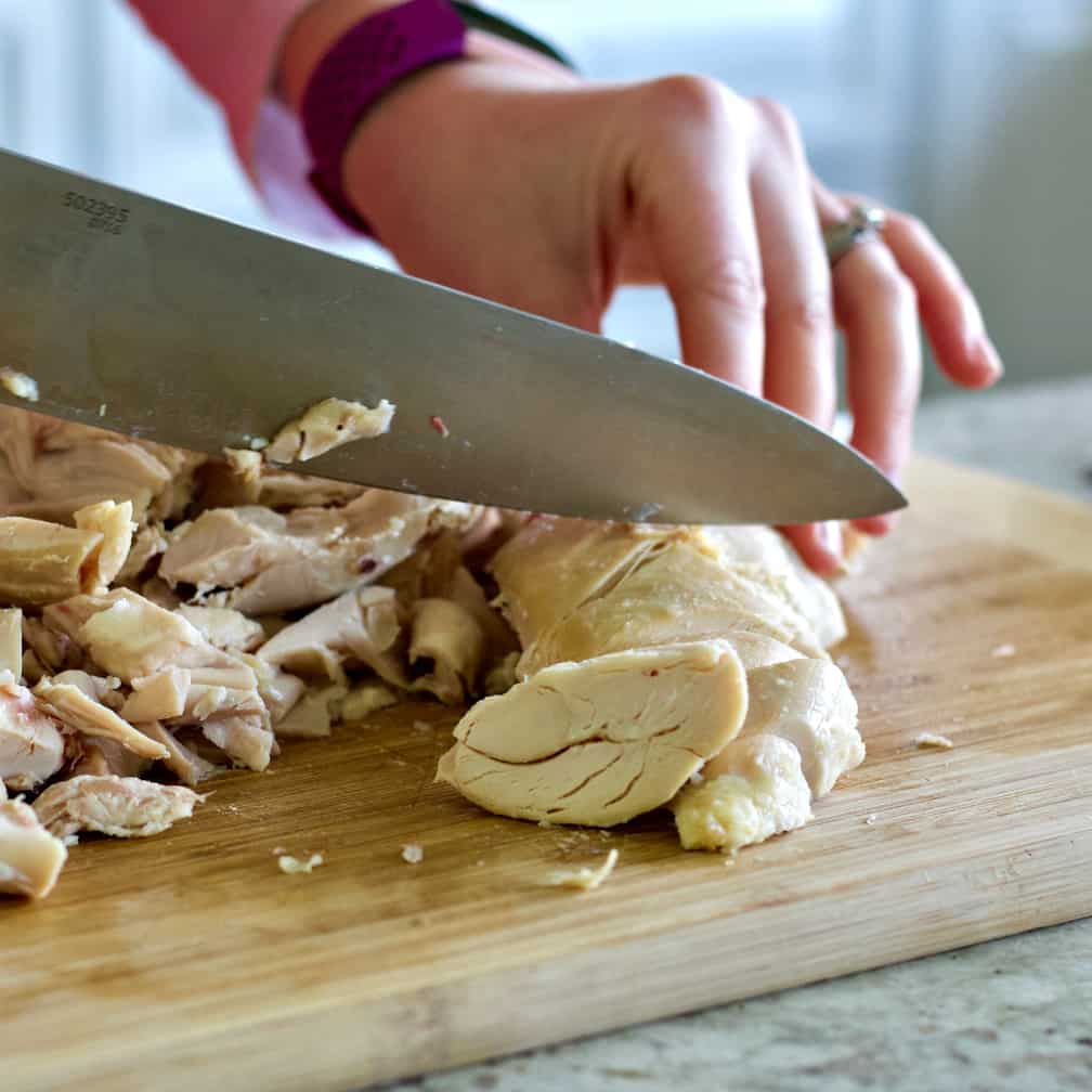chopping rotisserie chicken meat into bite sized pieces-chicken soup recipe