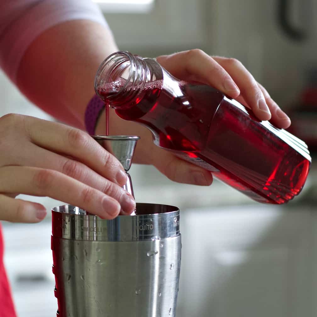 pouring grenadine for a Cosmopolitan drink