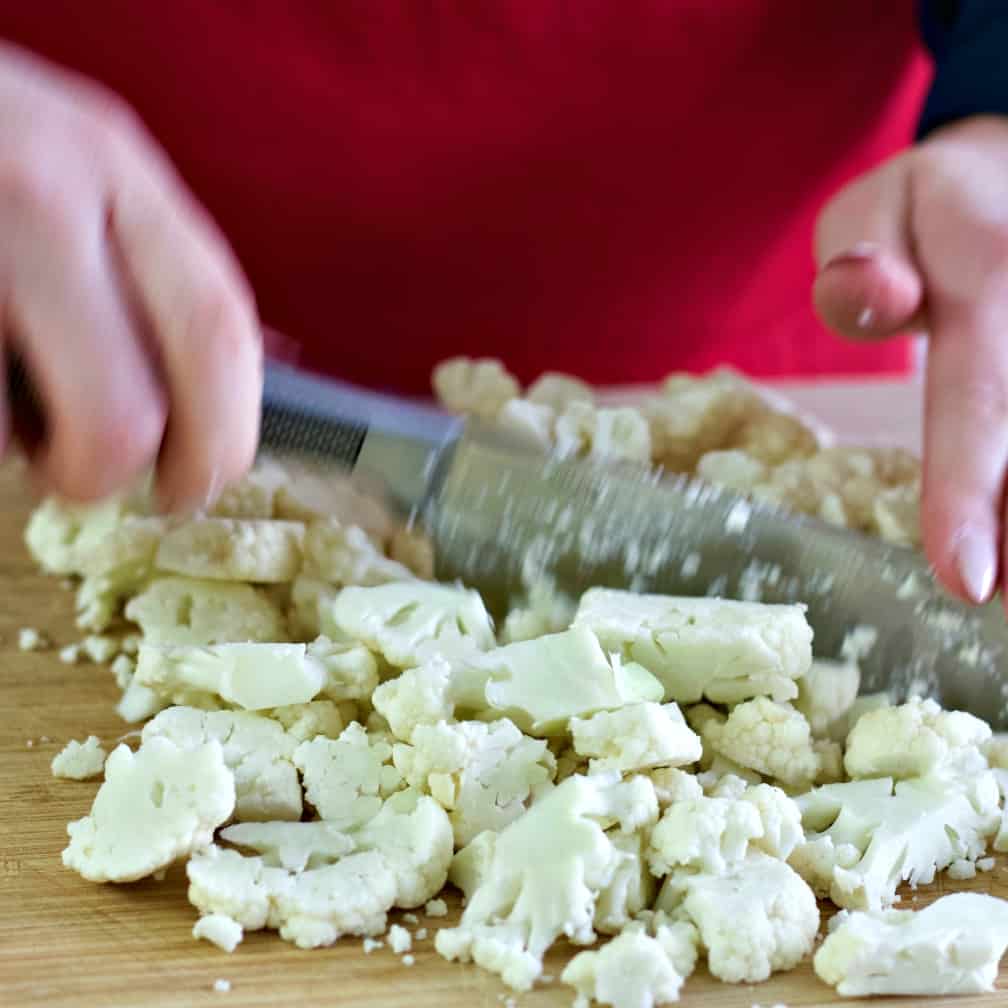 chopping cauliflower on a wooden board