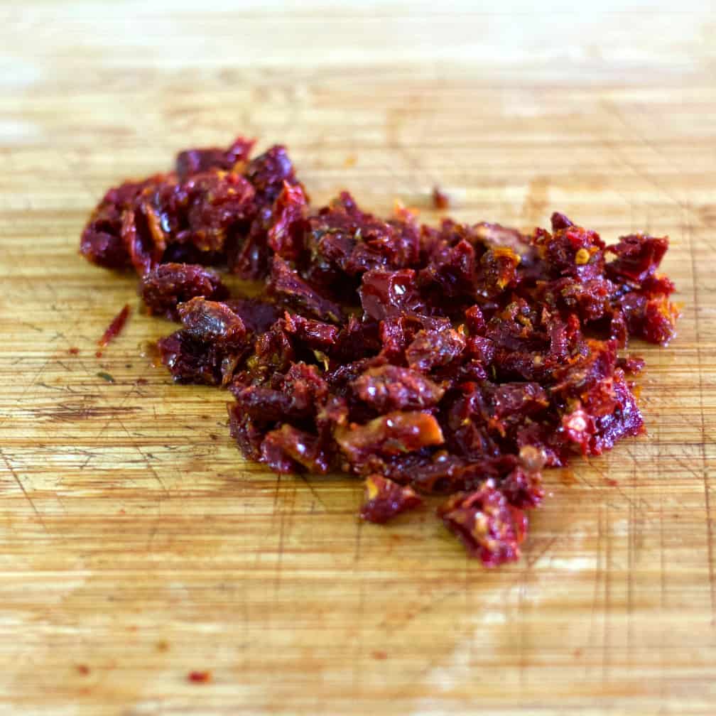 finely chopped sun dried tomatoes on a wooden board.-cauliflower salad