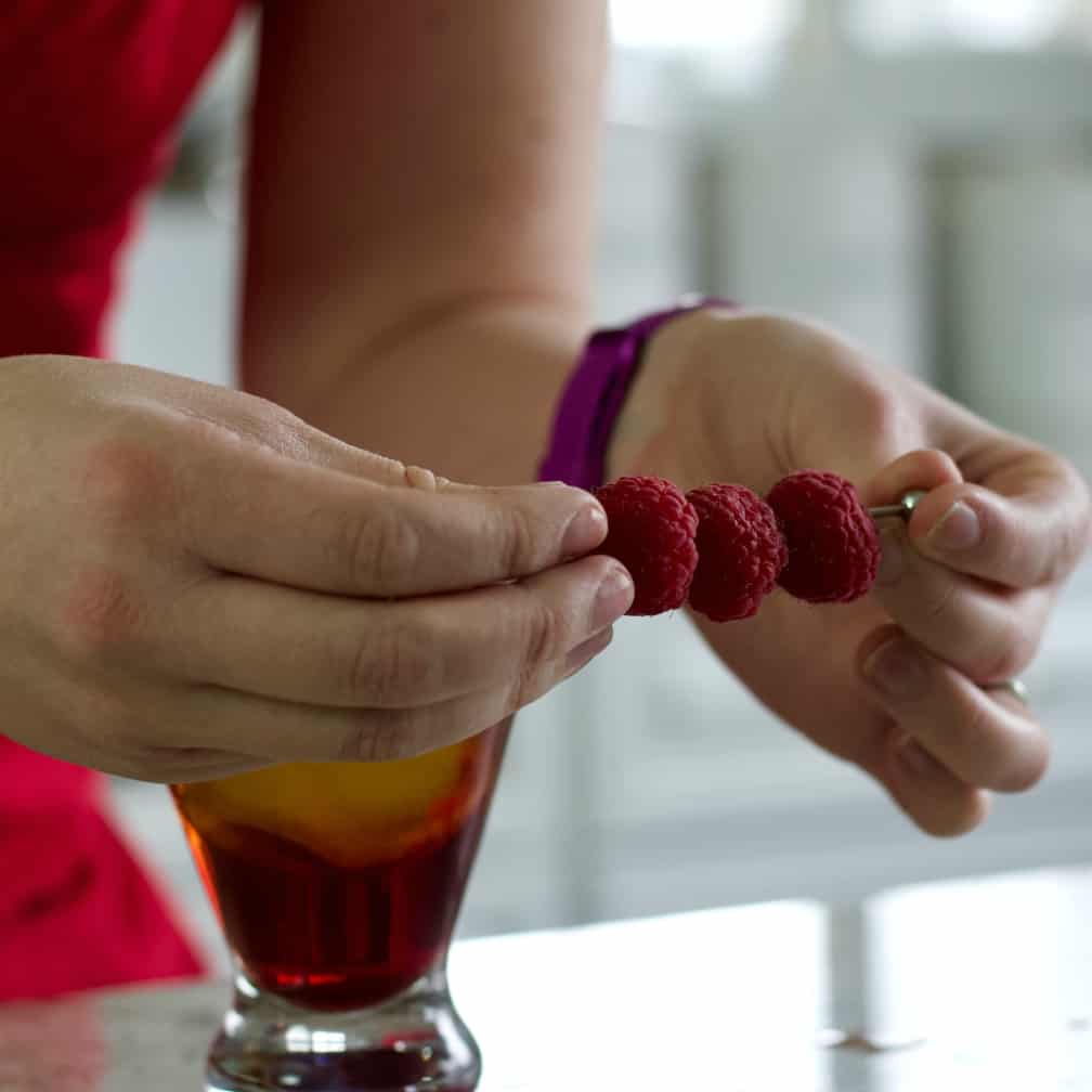 three fresh raspberries on a pick