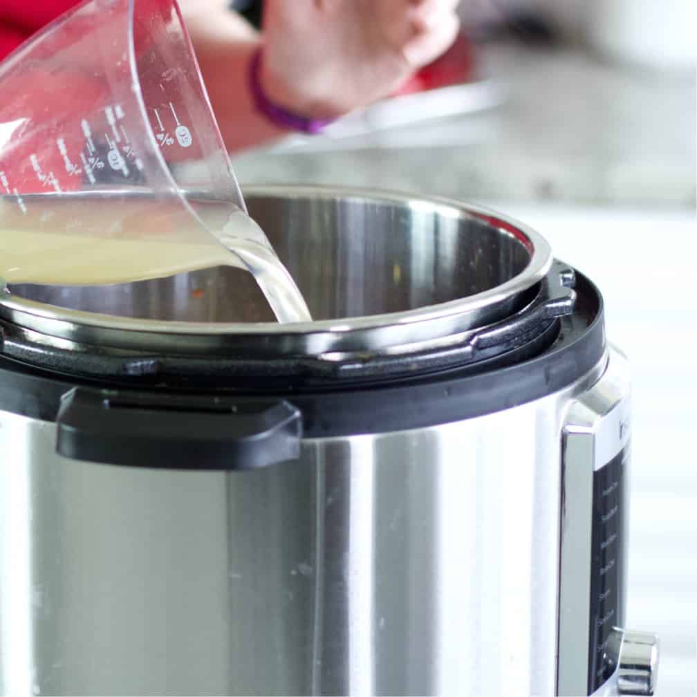 pouring chicken broth-chicken chili