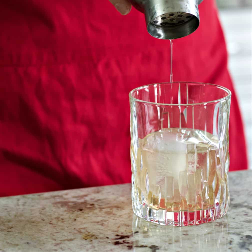 Straining peaches and cream cocktail