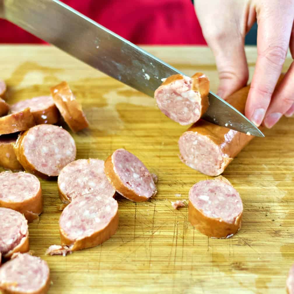 slicing smoked sausage-cabbage beef stew