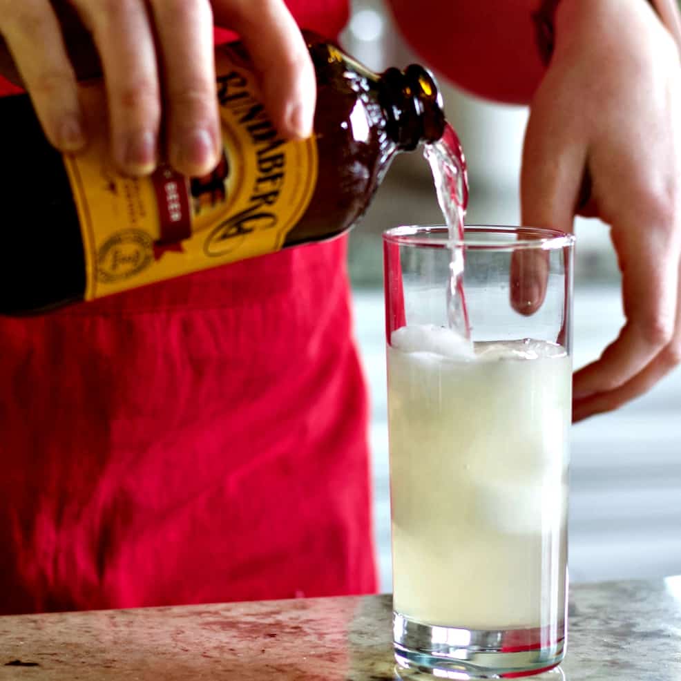 pouring ginger beer into Mezcal cocktail