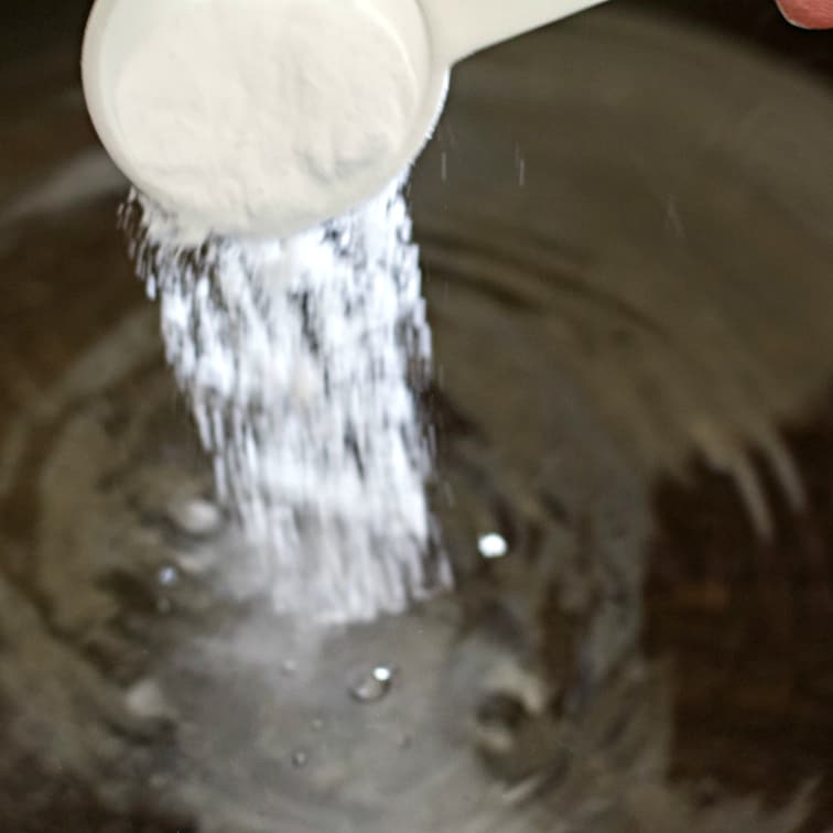 Pouring baking soda for boiling bagels