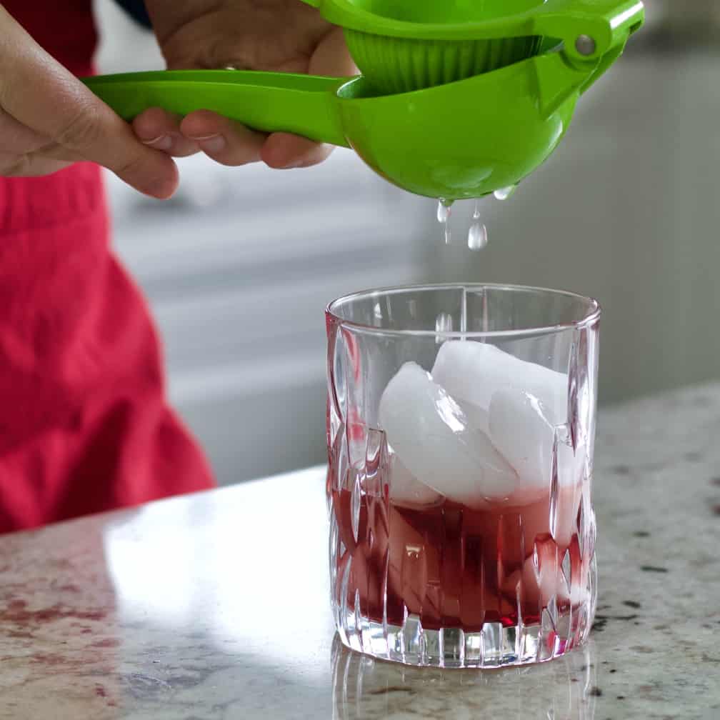 squeezing a lime over ice