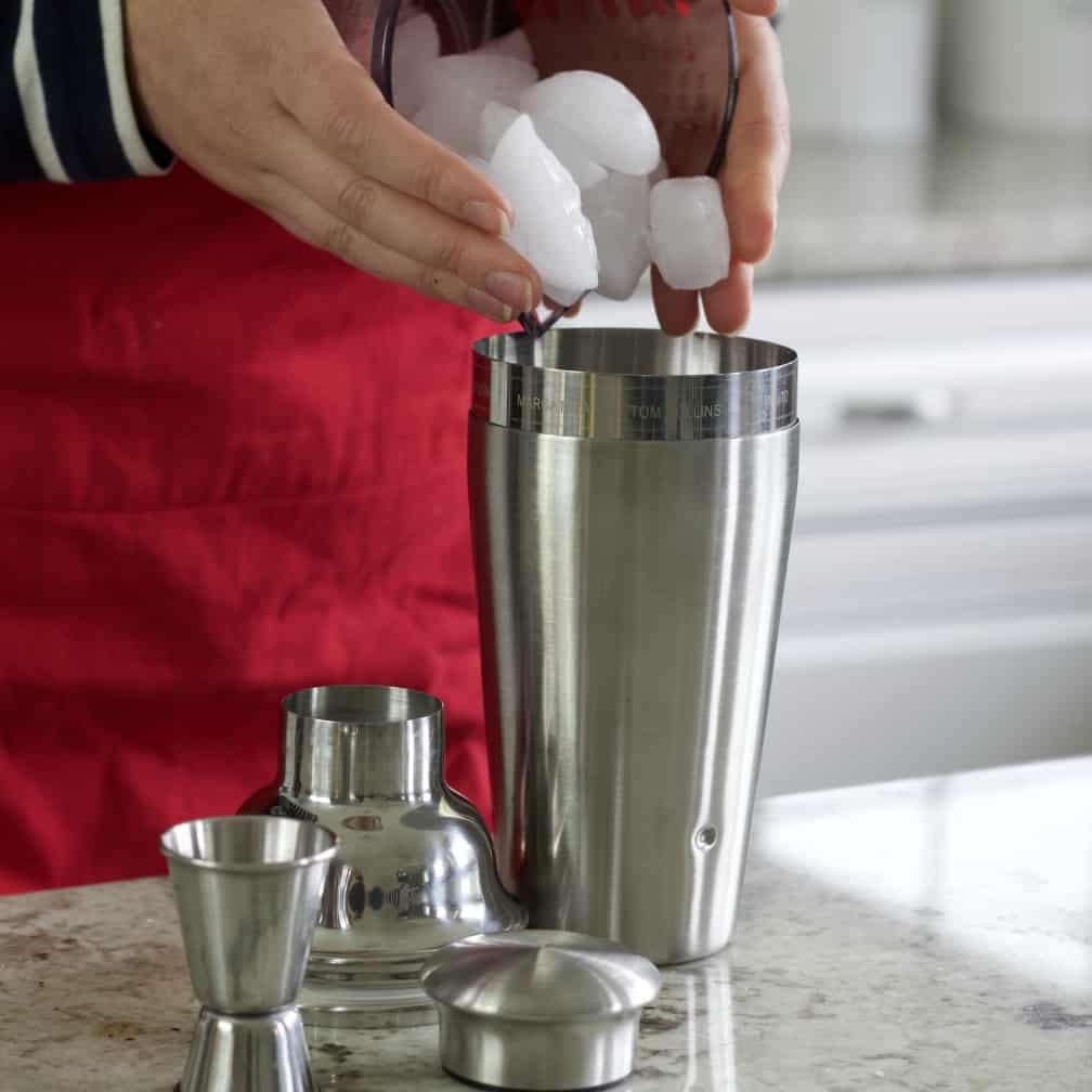 pouring ice into a cocktail shaker