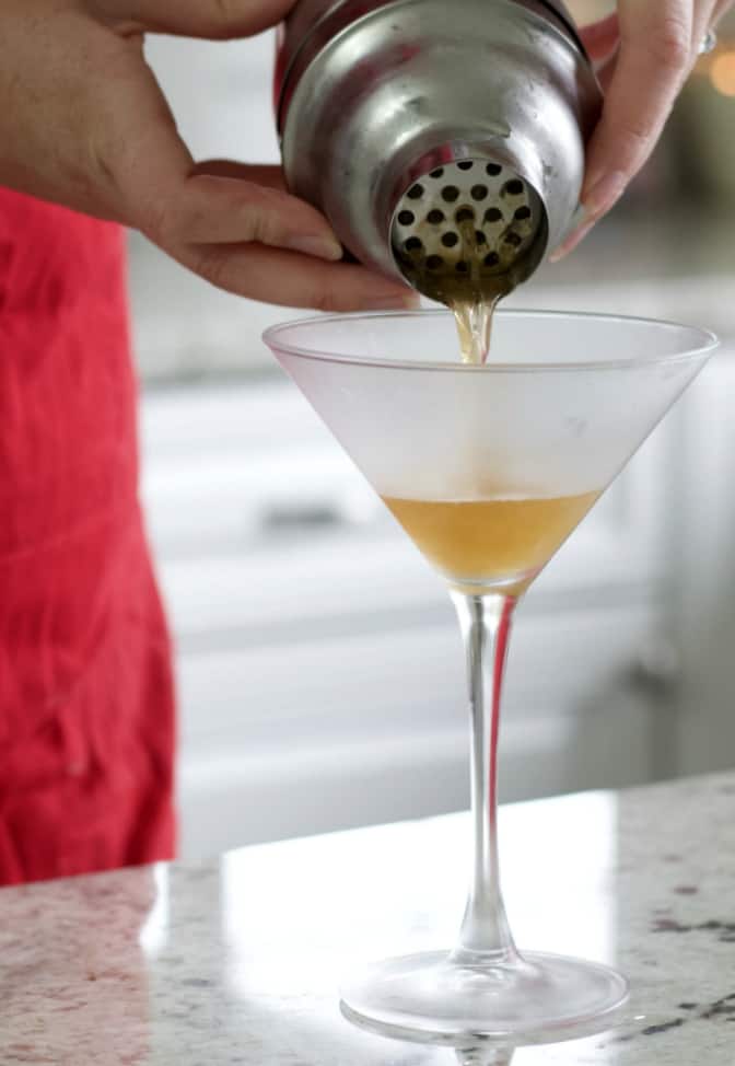 pouring banana split cocktail into chilled martini glass