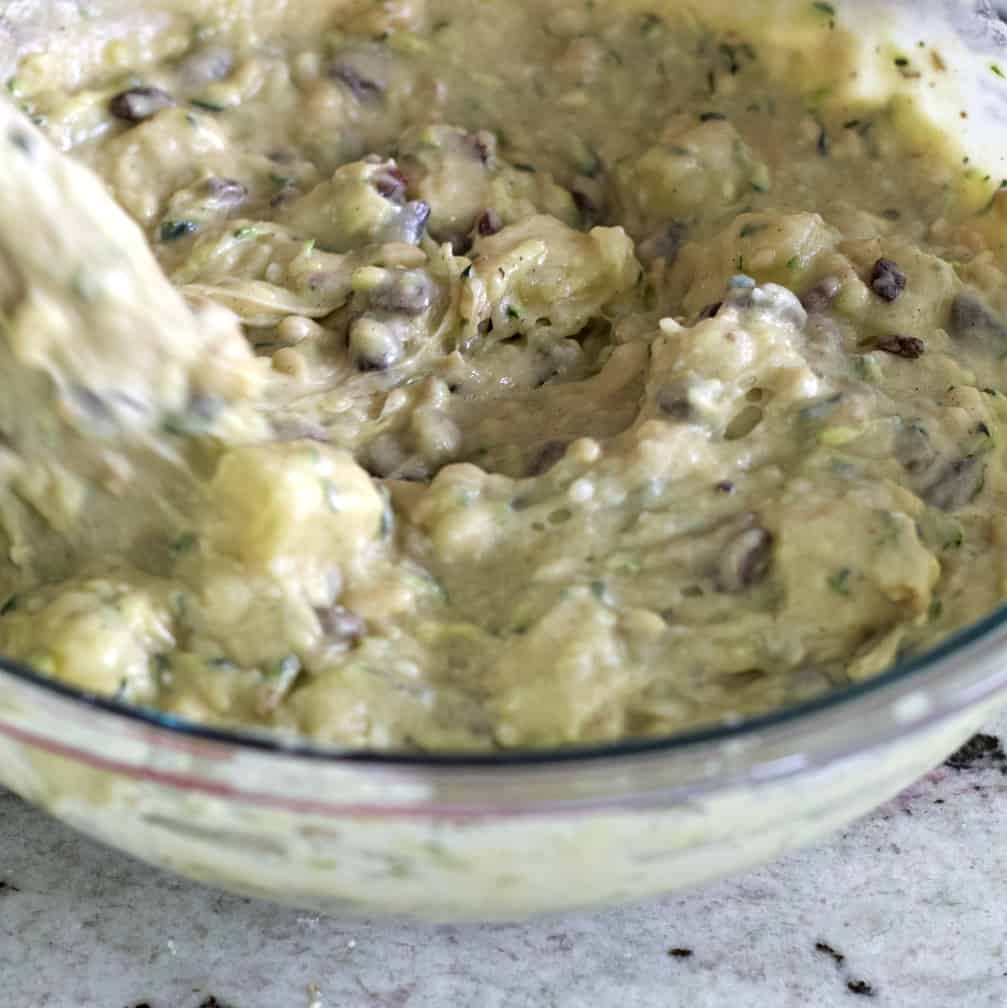 stirring zucchini bread batter with pineapple