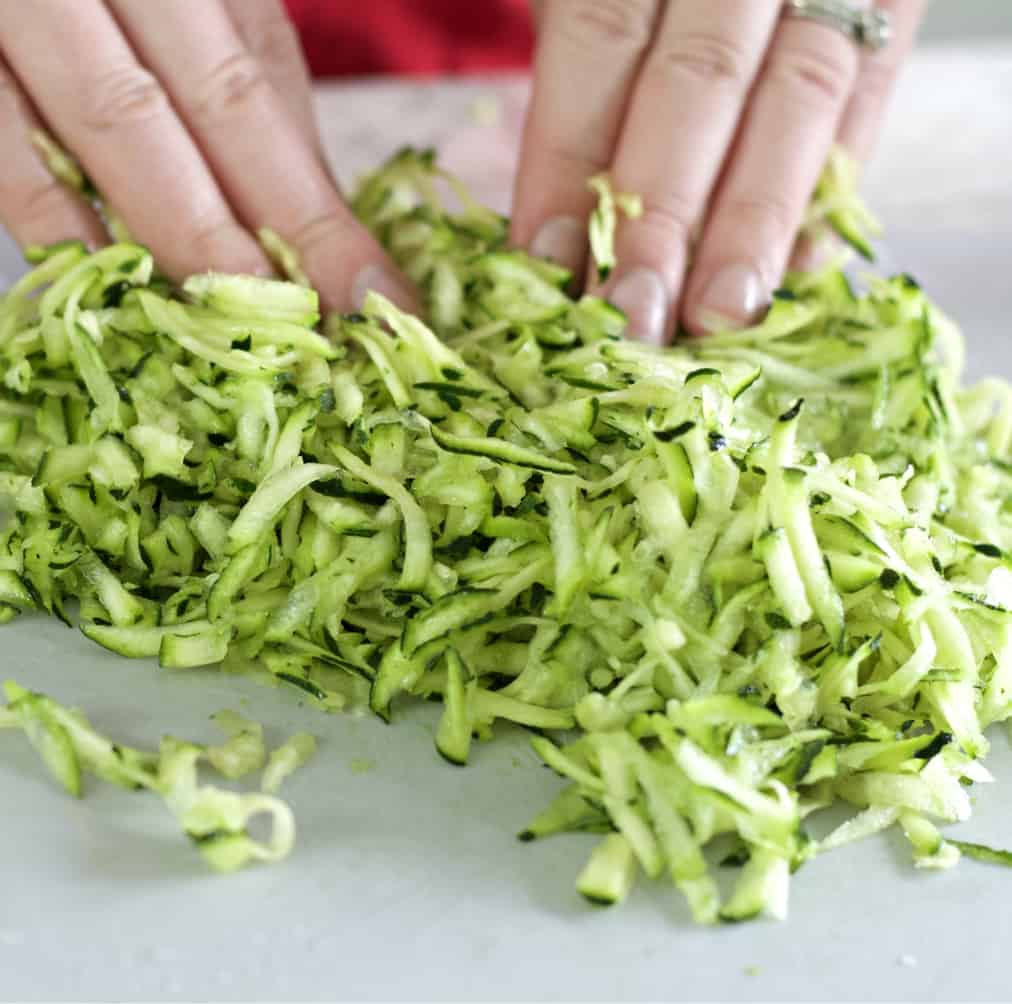 tossing shredded zucchini with sugar