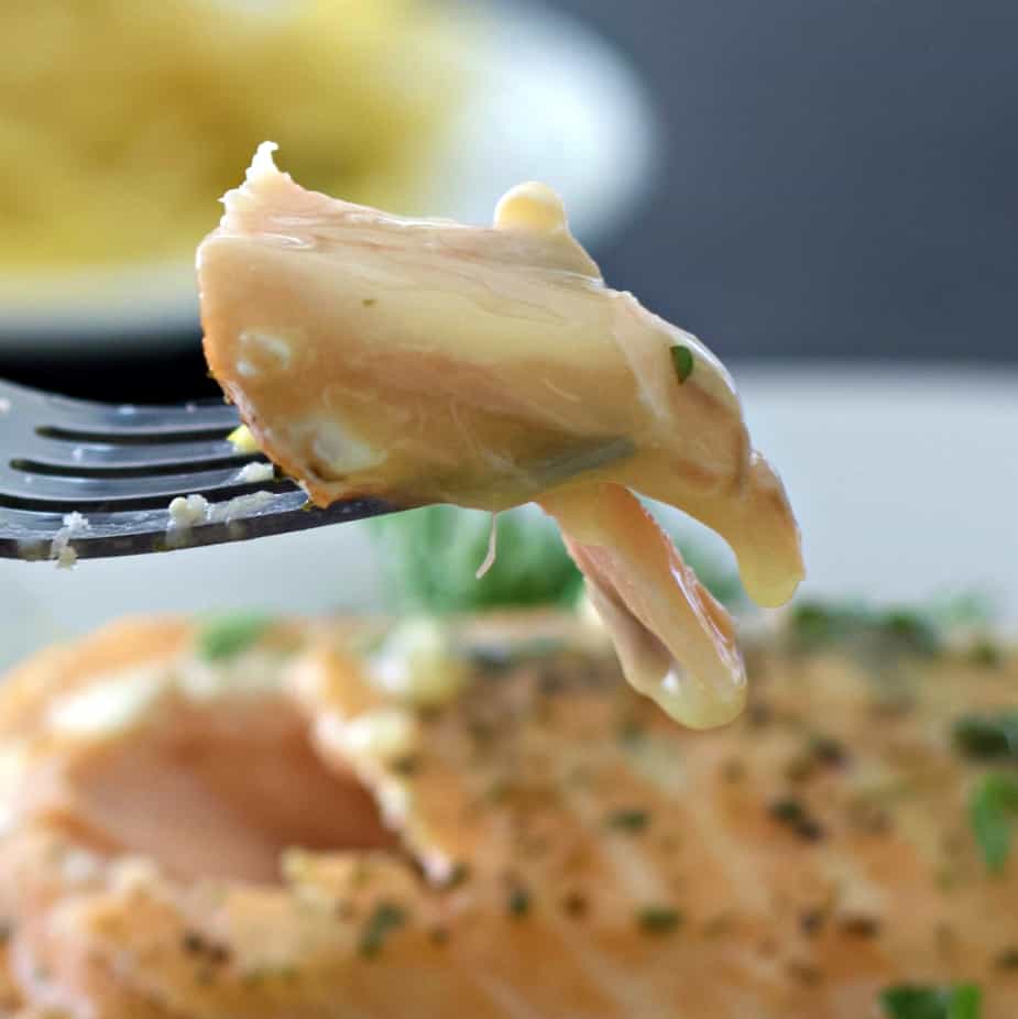 lemon butter sauce on salmon. One bite on a fork.