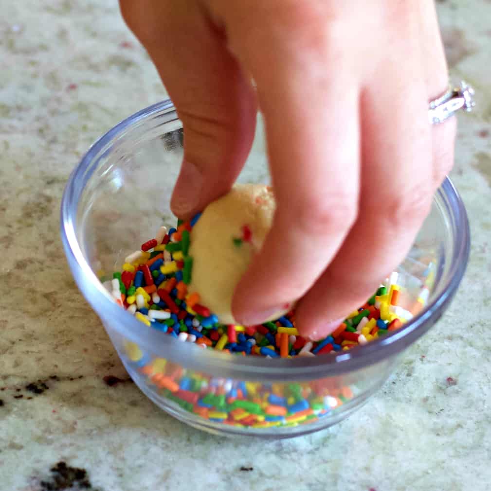 rolling cookie dough in sprinkles