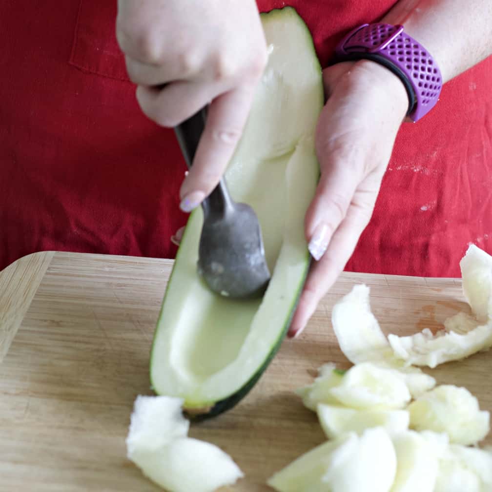 scooping out seeds-stuffed zucchini recipe