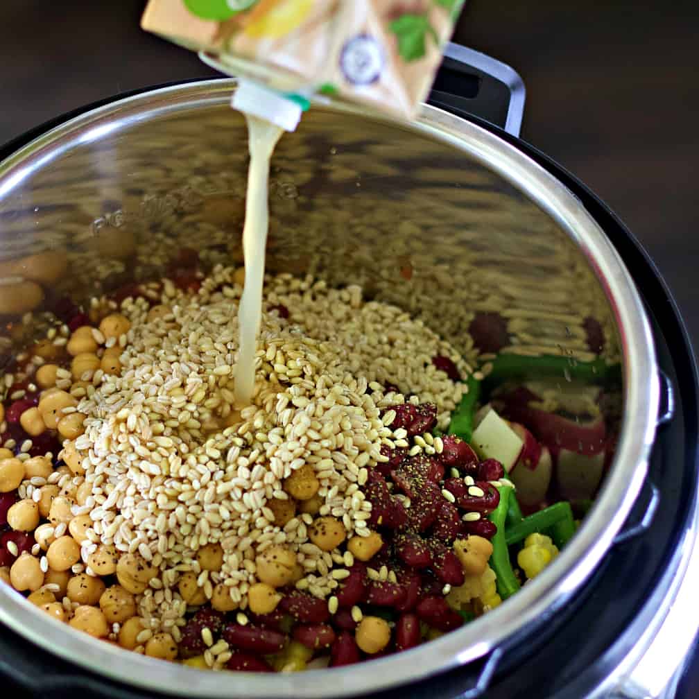 adding broth to vegetable soup