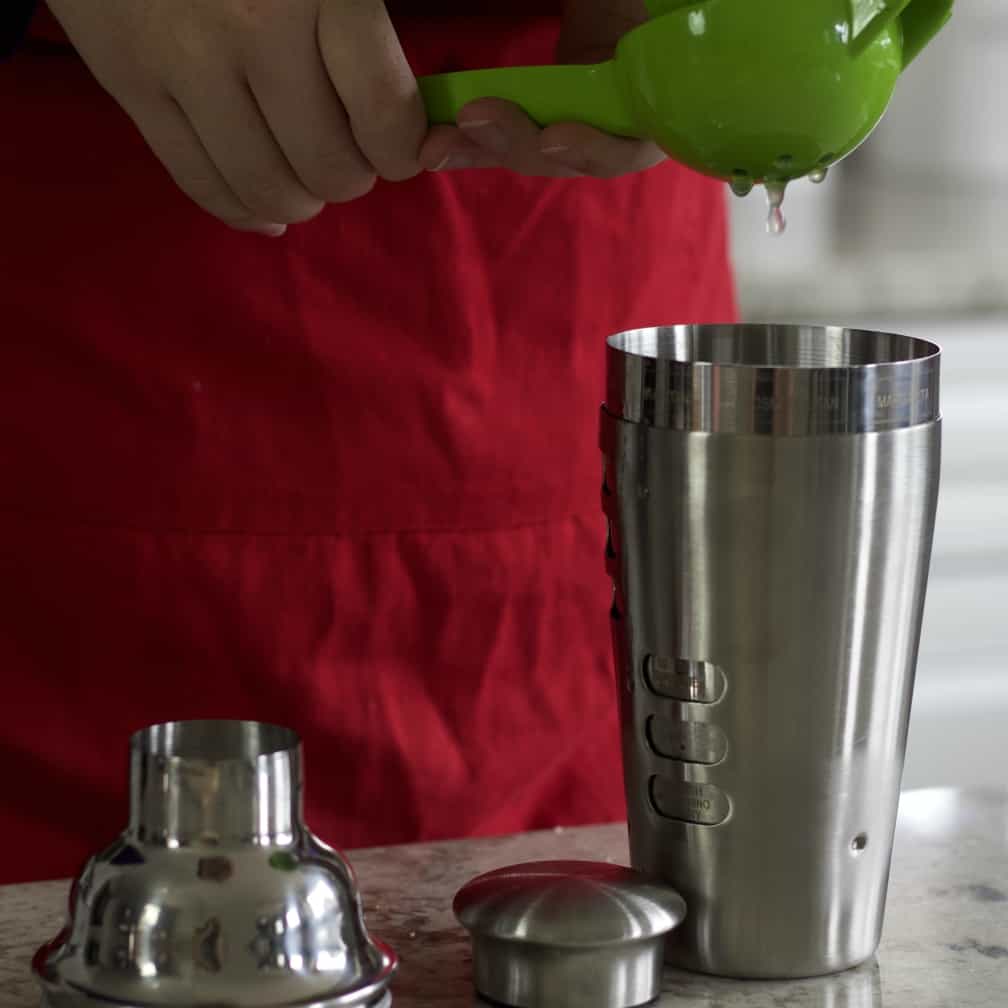 Cadillac Margarita Recipe with Grand Marnier 12 squeezing a lime into shaker
