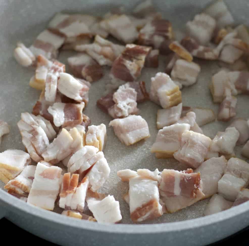 browning bacon in white skillet