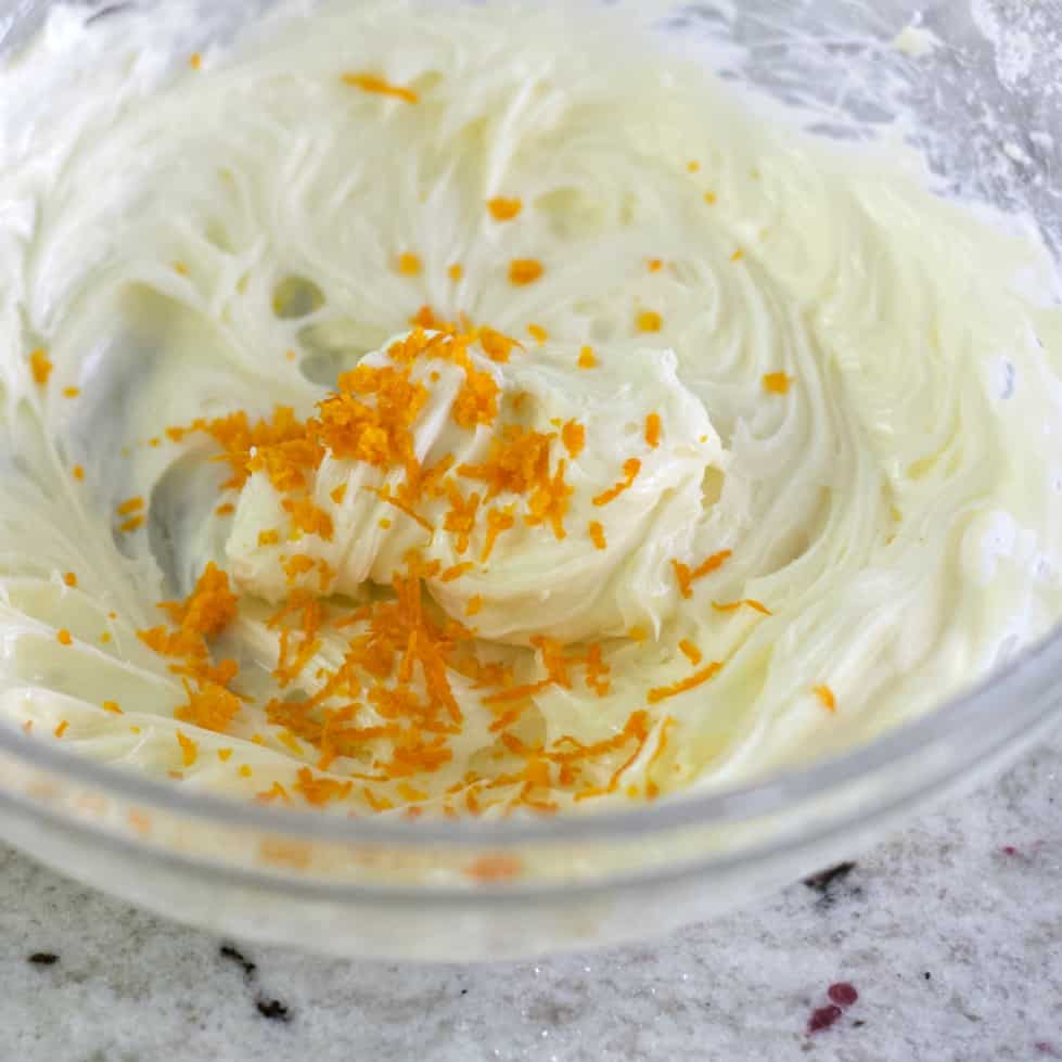 adding orange zest to the cranberry bliss bar frosting