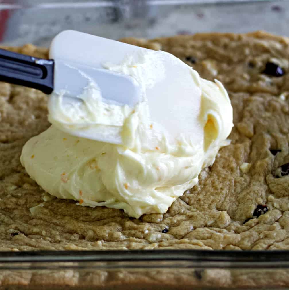 spreading frosting over cranberry bars
