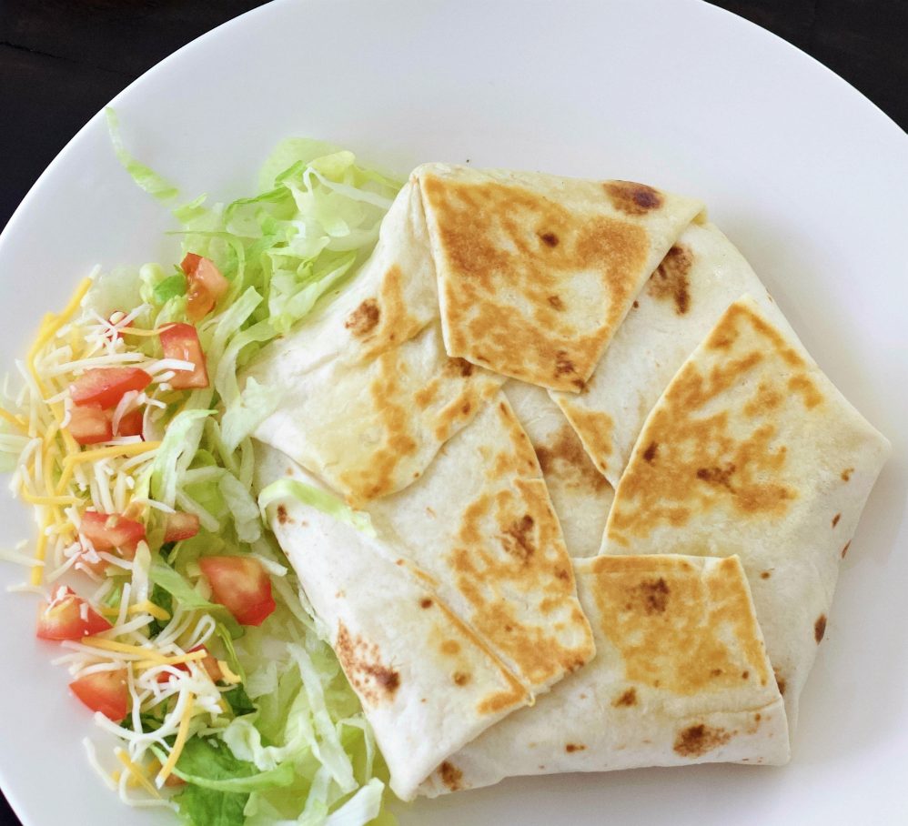 crunchwrap supreme plated with vegetables