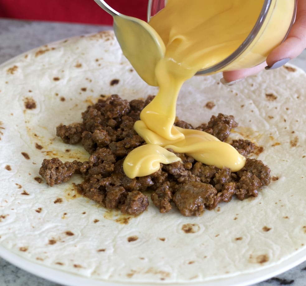 pouring on cheese sauce