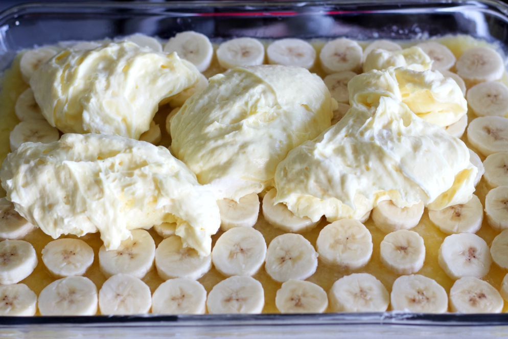 spreading on pudding over sliced bananas