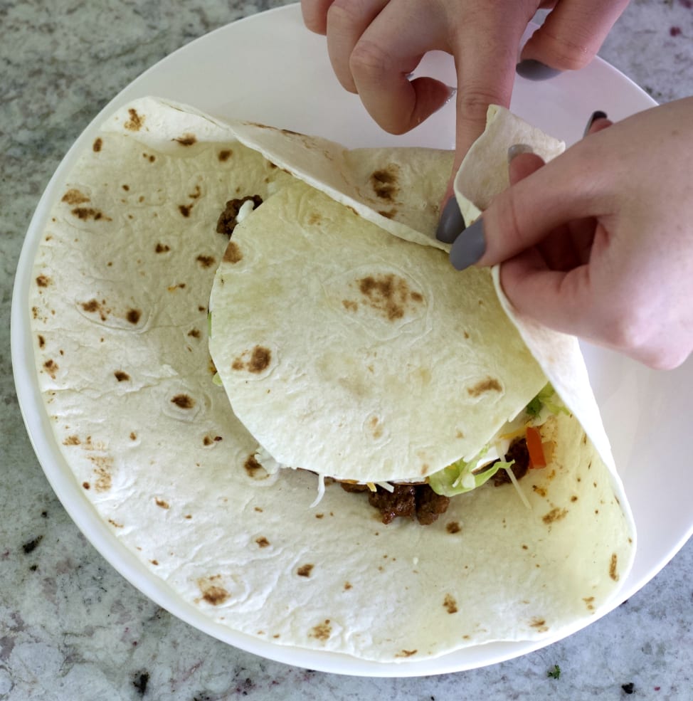 demonstrating a fold for the crunchwrap supreme