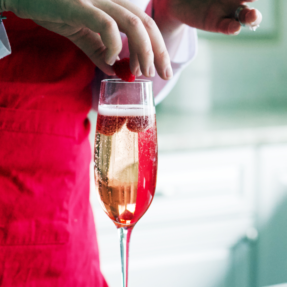 adding raspberries to top of cocktail