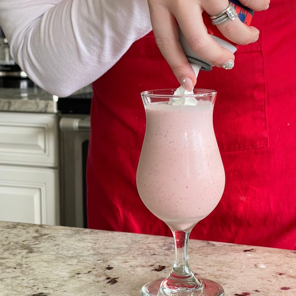 garnishing strawberry cocktail