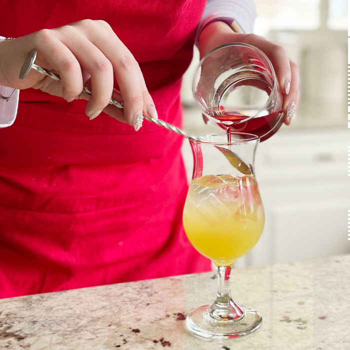 Pouring cranberry juice over back of spoon-layering