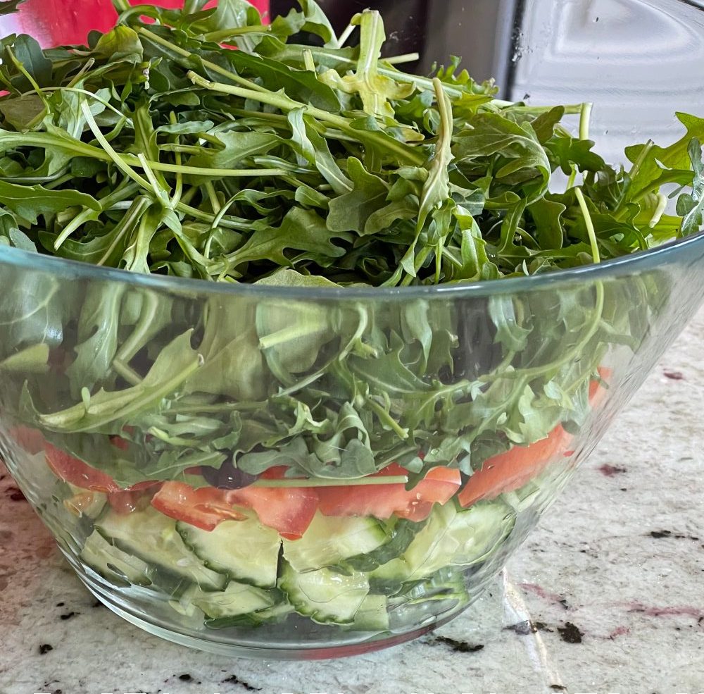 adding arugula-mediterranean salad