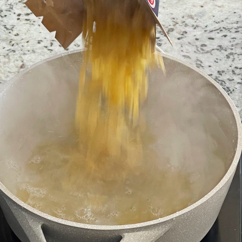 pouring pasta into boiling water