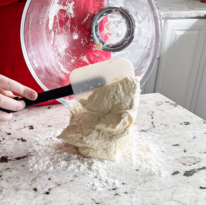 scooping flatbread dough onto floured board