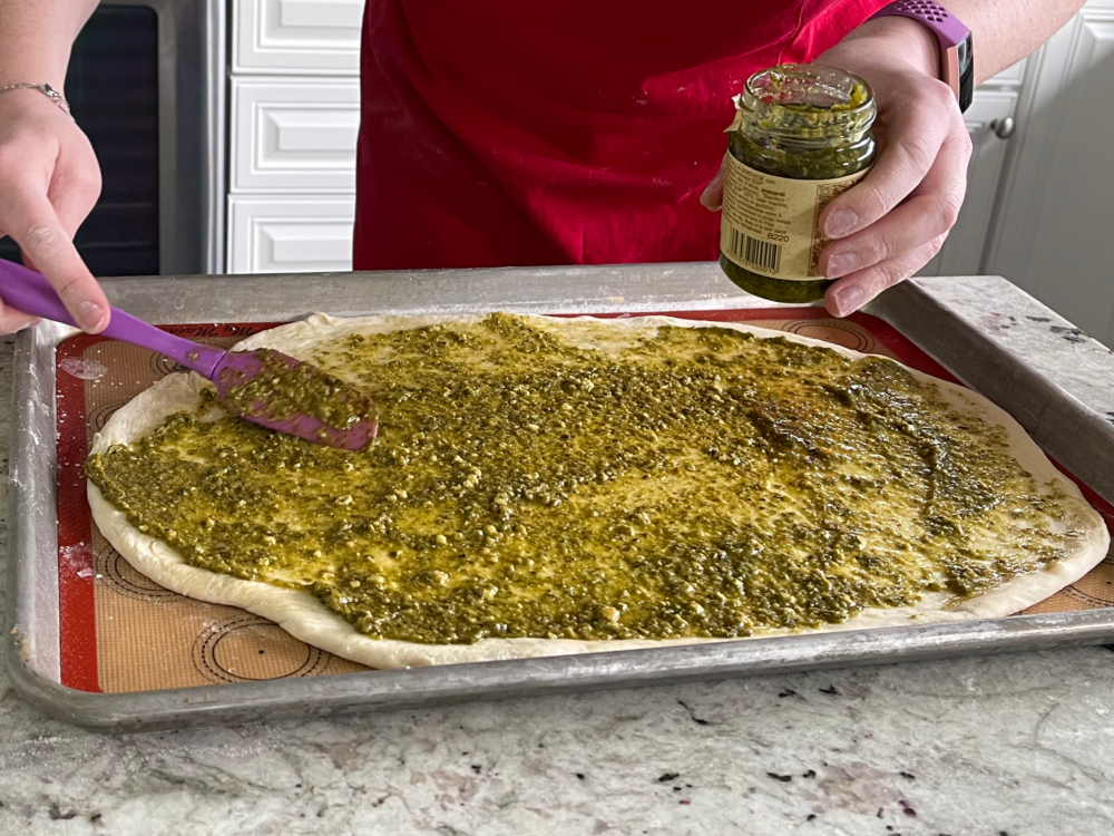 spreading pesto on flatbread