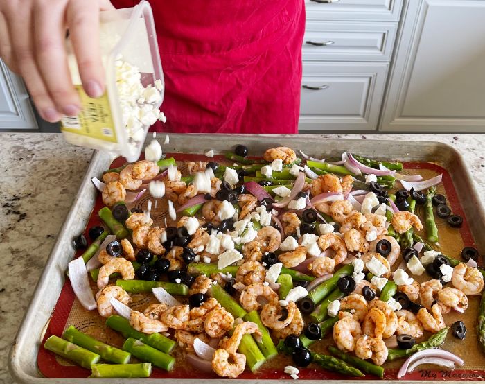 Mediterranean Shrimp Sheet Pan Dinner 21 sprinkling Feta over shrimp dinner