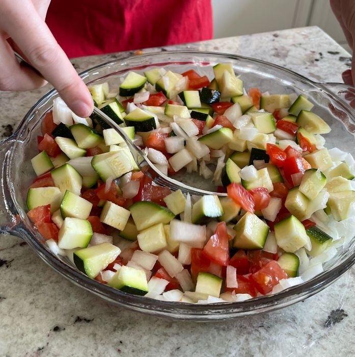 arranging chopped vegetables in oiled pie plate