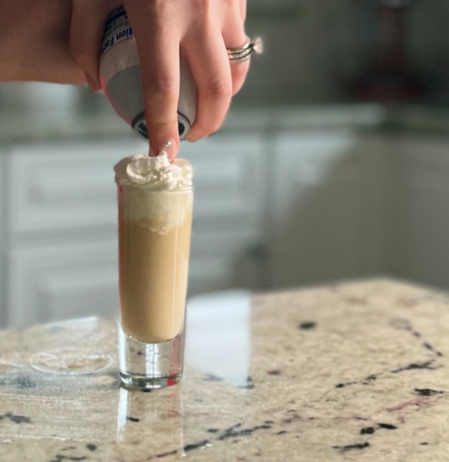 spraying whipped cream on top
