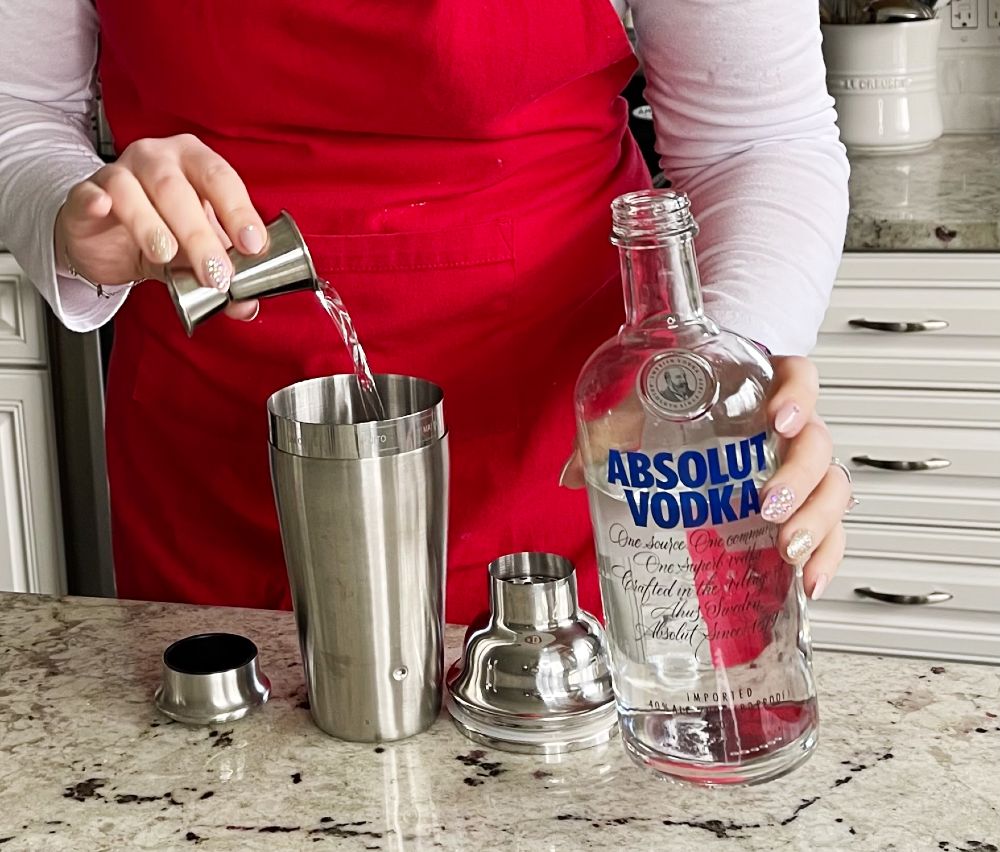 pouring vodka into a cocktail shaker