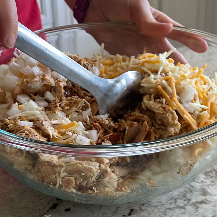 stirring completed chicken mixture-chicken enchilada casserole