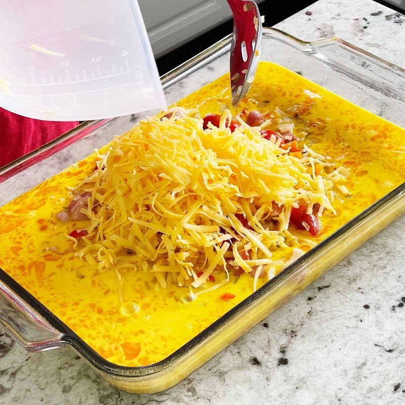 adding cheese to breakfast frittata mixture