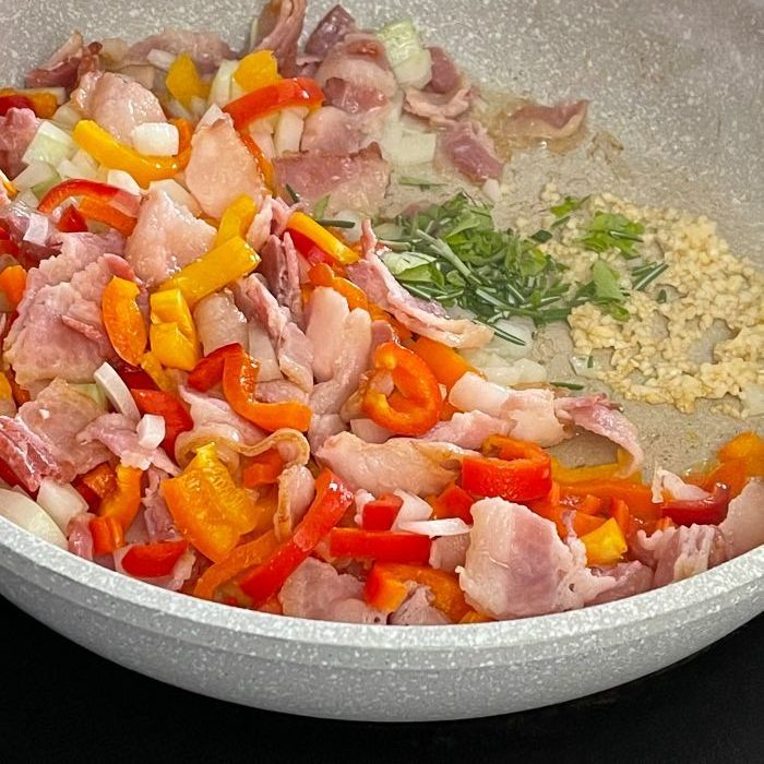 breakfast frittata-cooking bacon veggies, garlic and herbs together