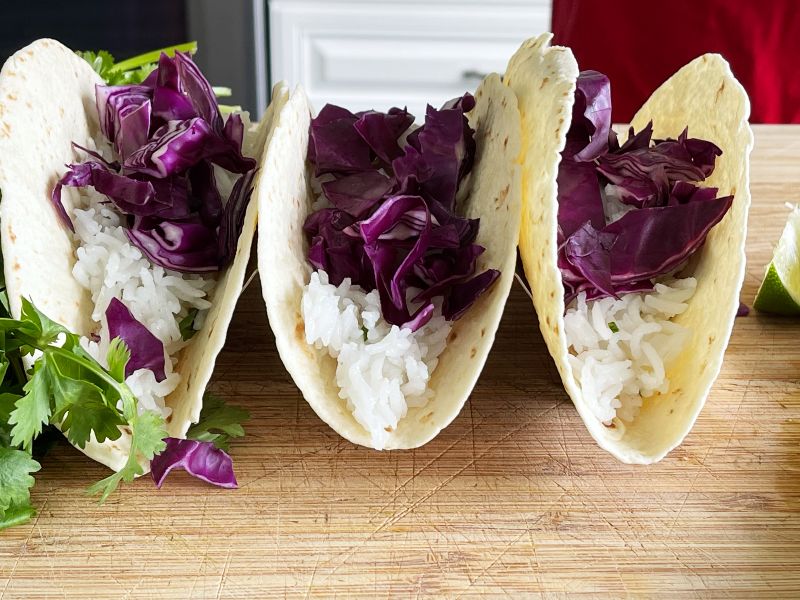 adding red cabbage to taco