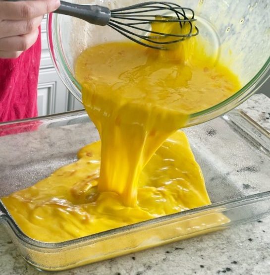 pouring egg mixture into oiled dish